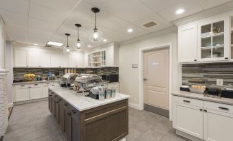 a kitchen with white cabinets and stainless steel appliances , including a refrigerator , oven , and microwave at Homewood Suites by Hilton Bloomington