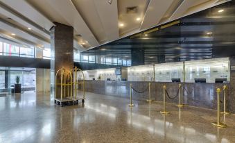 a large , open room with a gold birdcage in the center and a marble floor at Grand Mercure Recife Boa Viagem