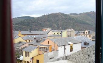 a view of a small town from a window , with buildings and mountains in the background at Hotel El Castillo