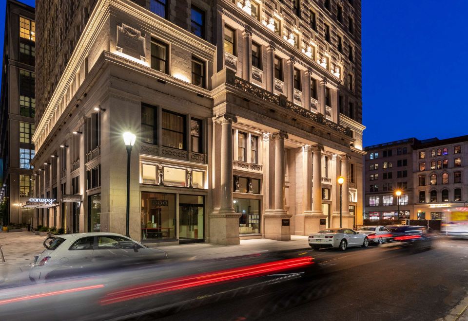 a city street with a tall building in the background and cars driving on it at Canopy by Hilton Philadelphia Center City