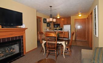 a dining room with a wooden table and chairs , a kitchen area , and a living room with a couch at Newport Resort