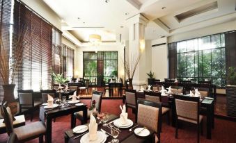 a well - lit dining room with multiple tables and chairs arranged for a large group of people at Tara Angkor Hotel