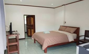 a bedroom with a large bed , wooden headboard , and a desk next to a closet at Smile Resort