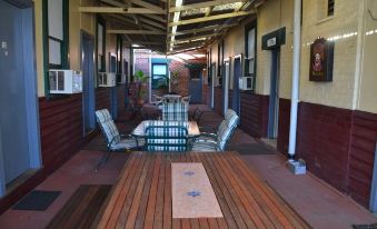 a covered outdoor area with a wooden floor and tables , featuring blue and white chairs at Black Diamond Lodge
