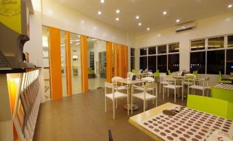 a restaurant with white tables and chairs , orange curtains , and a view of the outside through large windows at Yhotel