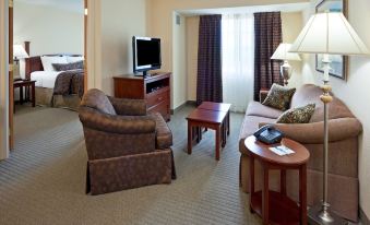 a living room with a brown couch , a chair , a television , and a coffee table at Staybridge Suites Philadelphia Valley Forge 422