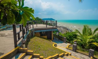 a wooden staircase leading down to a tropical beach , with the ocean visible in the background at Sea Horizon Resort