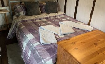 a cozy bedroom with a bed , two nightstands , and a wooden dresser , all neatly arranged at Myrtle Cottage