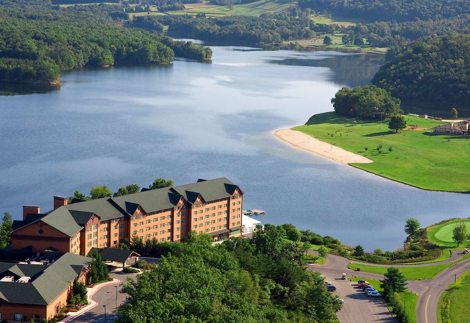 an aerial view of a large resort with a lake , golf course , and a building surrounded by trees at Rocky Gap Casino & Resort