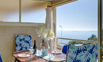 a dining table set for a meal , with a view of the ocean in the background at Zeus