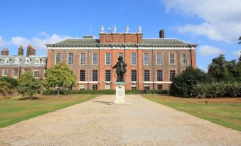 a large , red brick building with a statue of a man in front of it at The Hide London