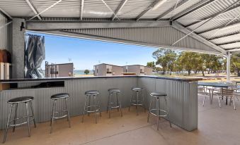 a covered outdoor area with several stools and tables , providing seating for guests and patrons at Discovery Parks - Lake Bonney