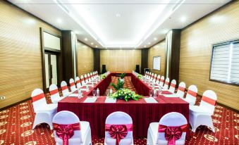 a formal dining room with a long table covered in red tablecloths , surrounded by chairs at Muong Thanh Grand Hoang Mai - Nghe An