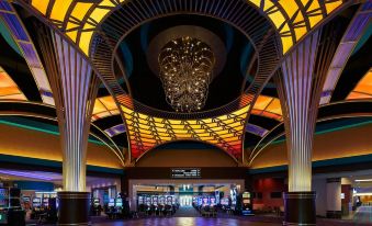 a modern , well - lit casino with multiple slot machines and a large chandelier hanging from the ceiling at Harrah's Ak-Chin Casino Resort