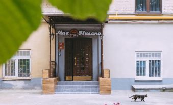 There is a building with two dogs in front and an entrance to the main doorway at Mia Milano Hotel