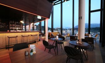 a modern bar with a view of the city , featuring comfortable seating and dining areas at Arte Hotel Salzburg