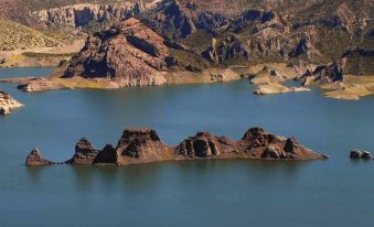 a mountainous landscape with a body of water in the foreground and a small island in the middle at Cabanas Del Sol