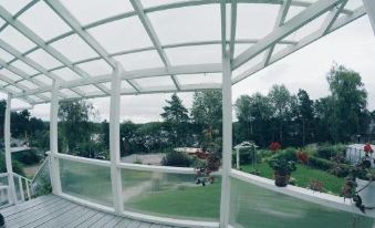 a covered patio with a glass roof , allowing natural light to fill the space while providing a view of the surrounding area at Ladya