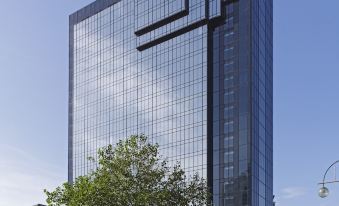 a modern office building with a large sign on its side , surrounded by trees and other buildings at Hyatt Regency Birmingham