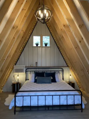 King bed in Tulip Glamping Aframe at Noble Pine Campground Отели рядом с достопримечательностью «Мамонтова пещера»