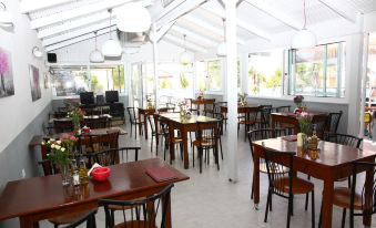 an empty dining room with several tables and chairs arranged for a group of people to enjoy a meal together at Happy Days