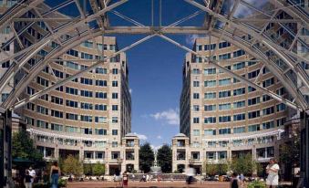 a large , modern building with multiple floors and high ceilings , surrounded by a courtyard filled with people at Courtyard by Marriott Fairfax Fair Oaks