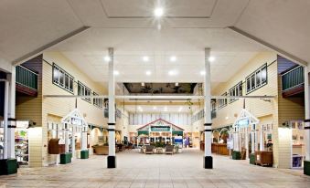 an empty shopping mall with a large open space in the center , surrounded by various stores and restaurants at Cairns Colonial Club Resort