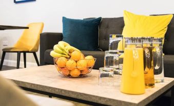 a living room with a couch , coffee table , and various items including lemons and oranges at 42 Apart-Hotel