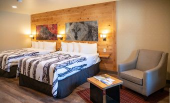 a cozy hotel room with a large bed , a couch , and a coffee table , all decorated in a modern style at Banff Rocky Mountain Resort