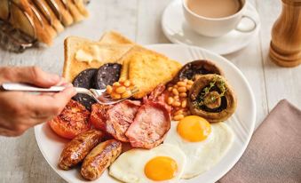 a delicious breakfast plate filled with various food items , including bacon , sausage , eggs , and toast at Huddersfield North