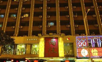 In the middle of the night, there is a large, brightly lit Asian building at Yile Hotel