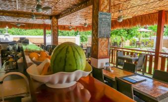 a dining area with a table and chairs , as well as a bowl of fruit on the table at Scent of Green Papaya