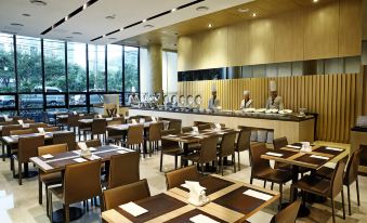 a large dining room with multiple tables and chairs arranged for a group of people to enjoy a meal together at Hotel the One