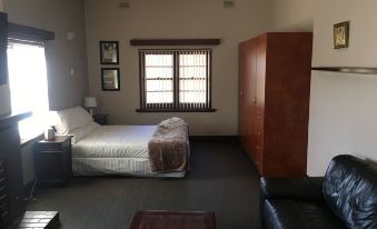 a room with a bed , a chair , and a window has a couch and a chair in the corner at The Civic Hotel