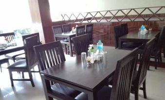 a dining room with several tables and chairs , some of which are occupied by people at Hotel Samana