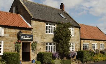 "a stone house with a sign that says "" the old granary "" is surrounded by greenery" at Ellerby Country Inn