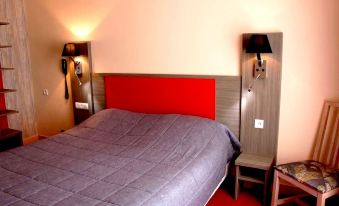 a bed with a red headboard and gray bedding is situated between two lamps on either side of a wall at Hôtel Saint-Hubert
