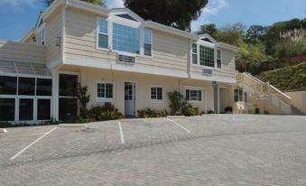 a two - story house with a car parked in the driveway and a person standing in front of it at Malibu Country Inn