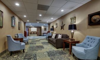 a spacious room with a variety of seating options , including couches , chairs , and a dining table at Hampton Inn & Suites Denver Littleton