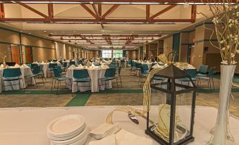 a large , well - lit banquet hall with multiple tables and chairs set up for a formal event at General Butler State Resort Park