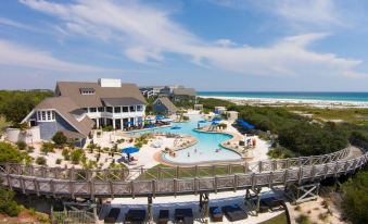 an aerial view of a resort with a large pool , multiple buildings , and people enjoying themselves at WaterSound Inn