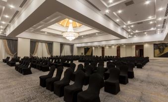 a large , well - lit conference room with rows of chairs arranged in a symmetrical fashion at Jolie Ville Hotel & Spa Kings Island Luxor