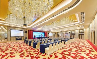 a large , well - lit conference room with rows of chairs arranged in front of a projector screen at Lakeside Hotel