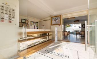 a hotel lobby with a reception desk , a dining area , and a hallway leading to the bathroom at Lagoa Hotel