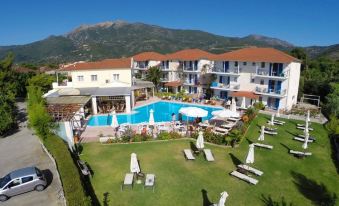 a resort with a large pool surrounded by lounge chairs and umbrellas , as well as a mountainous landscape in the background at G George