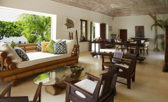 a spacious living room with various furniture , including a couch , chairs , and a dining table at GoldenEye