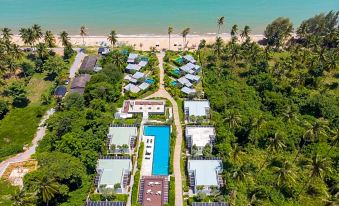 aerial view of a resort on a beach , surrounded by lush greenery and the ocean at Seanery Beach Resort