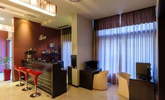 a modern living room with a bar area , featuring a red stool and a television at Park Hotel