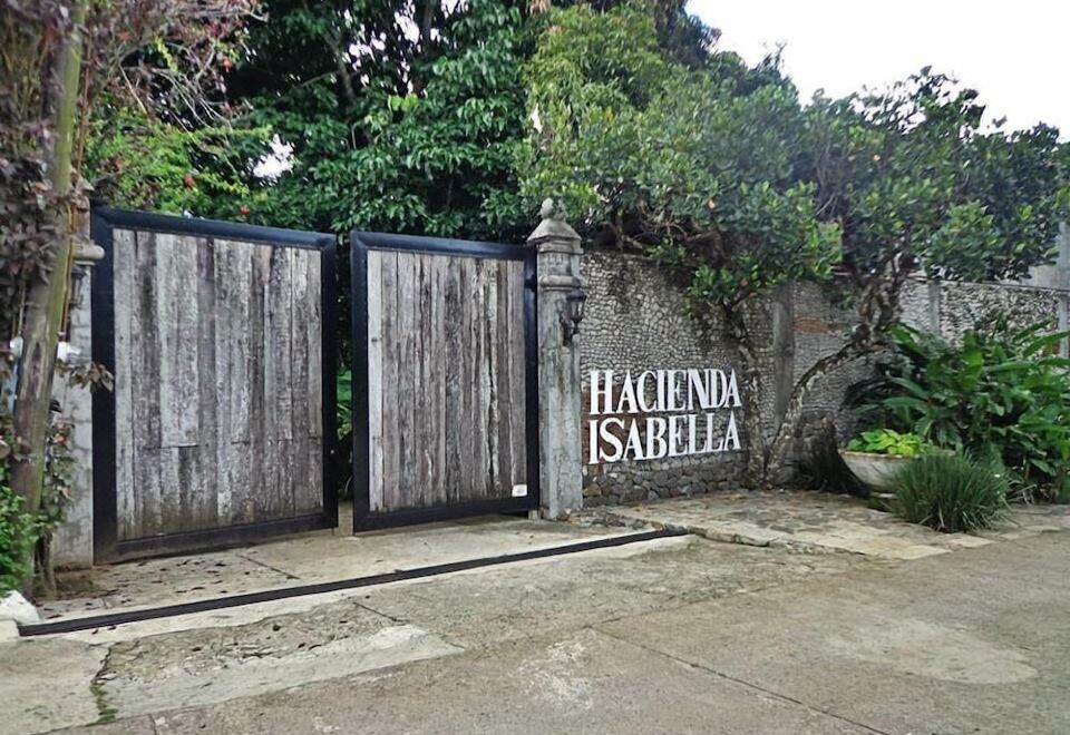 "a wooden gate with a sign that reads "" hacienda isabella "" is shown in front of a building" at Hacienda Isabella