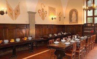 a dining room with wooden tables and chairs arranged for a group of people to enjoy a meal together at Villa Palazzola